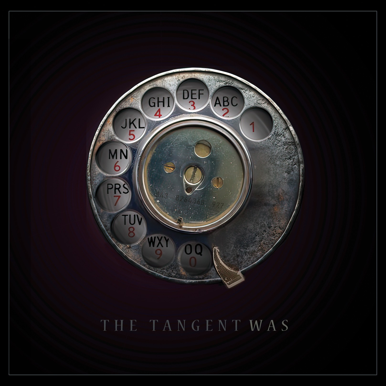La portada de «Was», de The Tangent: el disc de marcar d'un telèfon de roda antic sobre fons fosc