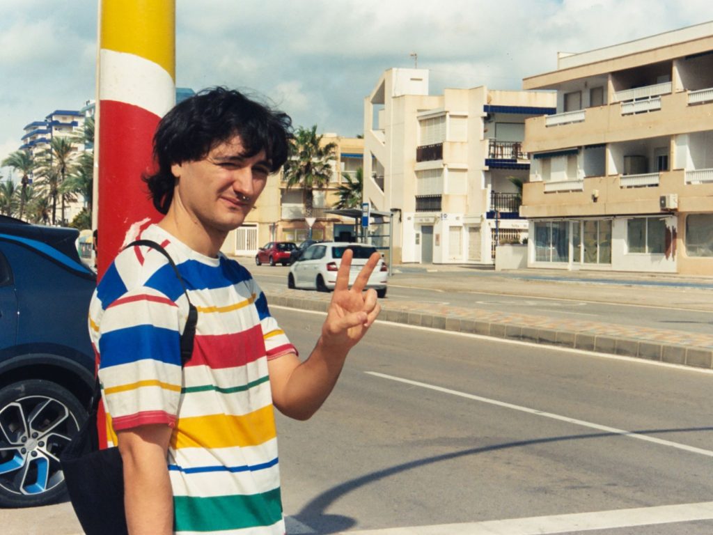 Pablo Gavira amb una samarreta de ratlles de colors al passeig marítim, en la fotografia que el Jamboree fa servir per al concert d'El Gavira