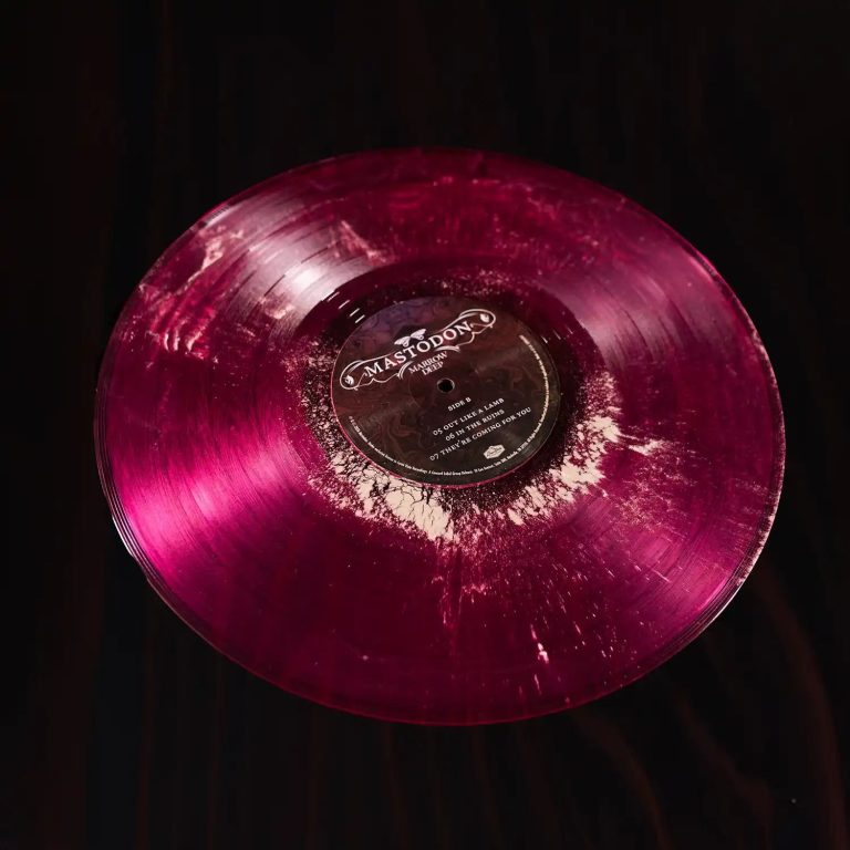 Cara B del vinil magenta de «Marrow Deep» de Mastodon, amb els grumolls blancs de pols d'os fòssil repartits pel solc