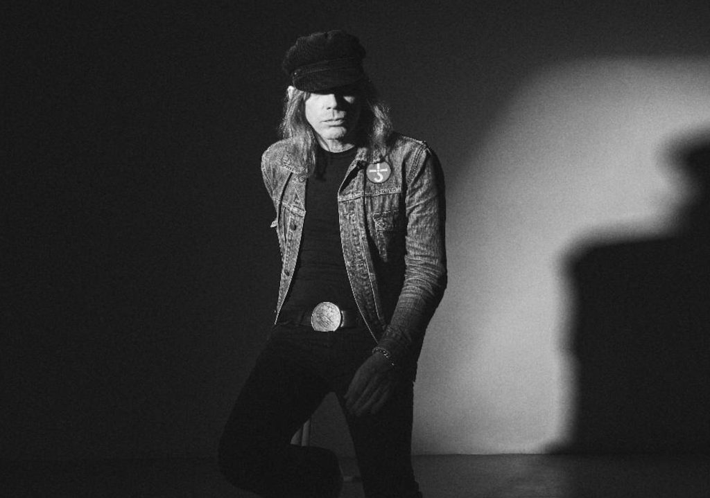 Nicke Andersson, dret i amb gorra, en el retrat en blanc i negre que acompanya l'anunci del seu primer disc en solitari