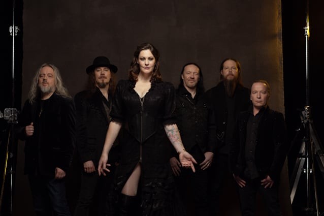 Foto de promoció de Nightwish: els sis membres del grup drets davant d'un fons fosc d'estudi, amb Floor Jansen al centre, vestida de negre