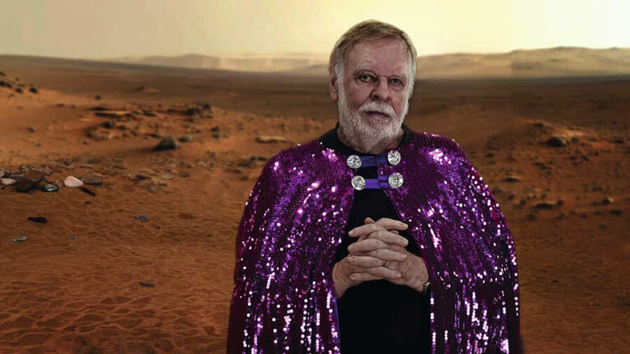 Rick Wakeman amb la capa de lluentons morada, fotomuntat damunt d'un paisatge marcià, a la imatge de promoció de «Return to the Red Planet»